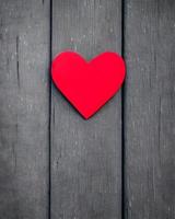 adesivo em forma de coração de amor vermelho na mesa de madeira foto