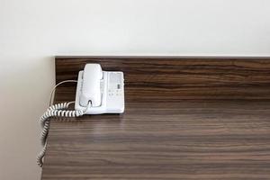 telefone branco sobre a mesa em um quarto de hotel foto