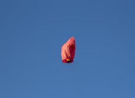lanterna voadora em forma de coração chinês vermelho voa, lanterna voadora, balão de ar quente. lanterna voa alto no céu azul. foto