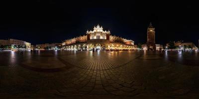 noite completa 360 panorama na principal praça do mercado no centro da cidade velha com edifícios históricos, templos e prefeitura com muitos turistas em projeção equiretangular foto