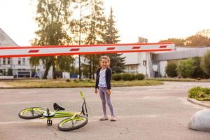 menina em uma bicicleta perto da barreira foto