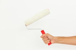 mão de uma mulher segurando um rolo de pintura isolado em um fundo branco foto