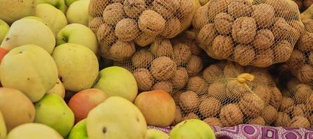 nozes e maçãs no balcão do mercado de agricultores, foco seletivo em produtos maduros, vitrine em mantimentos foto