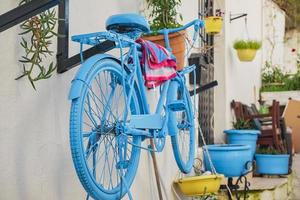 bicicleta velha em um café na rua na cidade velha. rua aconchegante com flores e café na costa mediterrânea. decoração de fachada de uma cafeteria com bicicleta. foto