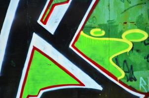 a parede velha, pintada em grafite colorido desenhando tintas aerossol verde. imagem de fundo sobre o tema do desenho de graffiti e arte de rua foto