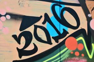 a parede velha, pintada em desenho de grafite colorido com tintas aerossóis. imagem de fundo sobre o tema do desenho de graffiti e arte de rua foto