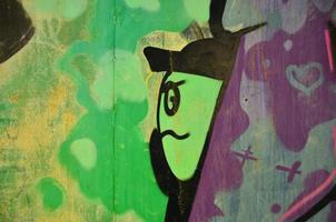 a parede velha, pintada em grafite colorido desenhando tintas aerossol verde. imagem de fundo sobre o tema do desenho de graffiti e arte de rua foto