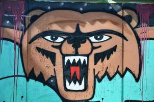 a parede velha, pintada em desenho de grafite colorido com tintas aerossóis. imagem de uma cara de urso terrível foto