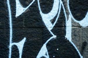 fragmento de desenhos de grafite. a velha parede decorada com manchas de tinta no estilo da cultura da arte de rua. textura de fundo colorido foto