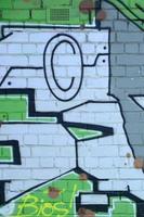fragmento de desenhos de grafite. a parede antiga decorada com manchas de tinta no estilo da cultura da arte de rua. textura de fundo colorido em tons de verde foto