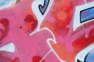 fragmento de desenhos de grafite. a velha parede decorada com manchas de tinta no estilo da cultura da arte de rua. textura de fundo colorido em tons quentes foto