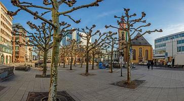 vista sobre a praça no hauptwache em frankfurt com st. a igreja de catherine e os arranha-céus do horizonte na luz da manhã foto