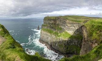 vista sobre a linha do penhasco das falésias de moher na irlanda durante o dia foto