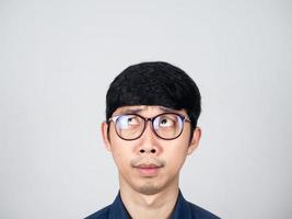 jovem empresário usa óculos se sente confuso no rosto olhando para cima tiro de estúdio isolado foto