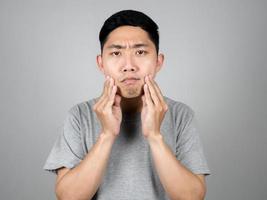 jovem sério com o rosto sobre seus cuidados com a pele e acne isolada foto