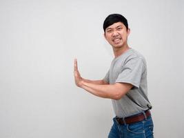 jovem asiático gesto de camisa cinza empurre suas mãos parece pesado isolado foto