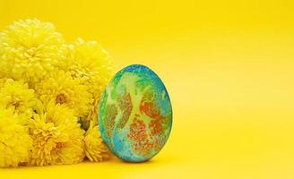 crisântemos amarelos com ovo colorido. minimalismo. páscoa. copie o espaço foto