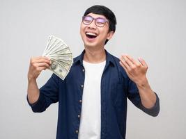homem asiático alegre se sente feliz e balança dinheiro na mão isolado foto