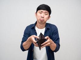 pobre homem asiático mostra carteira vazia sente-se infeliz isolado foto