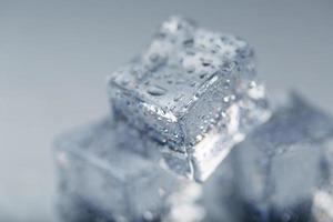 cubo de gelo com gotas de água close-up em macro sobre um fundo branco. gelo refrescante. isolar foto