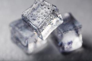 cubo de gelo com gotas de água close-up em macro sobre um fundo branco. gelo refrescante. isolar foto