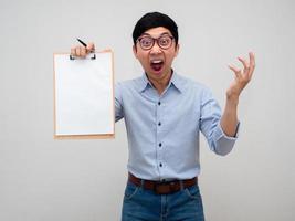 empresário asiático usa óculos camisa azul se sente chocado mostra quadro de documentos em sua mão isolado foto