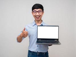 empresário asiático positivo sorriso feliz mostra laptop tela branca mostra polegar para cima isolado foto