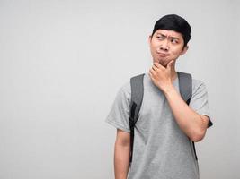 homem positivo com mochila escolar gesto alegre pensativo e pensando em estudar foto