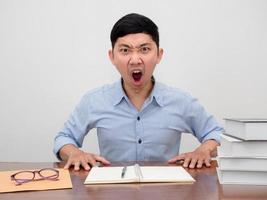 empresário asiático sentado na mesa de trabalho sente raiva bate na mesa diz não foto