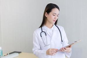 médico de mulher asiática examinar documento de relatório foto
