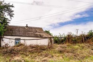 linda e velha casa de fazenda abandonada na zona rural em fundo natural foto