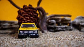 carro de brinquedo transportando pinhas em um fundo laranja foto