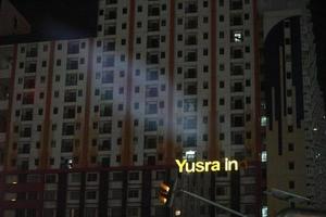 bekasi, indonésia em julho de 2022. logotipo do yusra inn que brilha no escuro. yusra inn é um dos hotéis perto de pakuwon bekasi foto