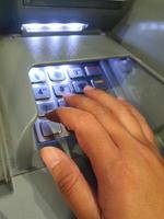 oeste de java, indonésia em julho de 2022. uma mão está pressionando o teclado numérico em um caixa eletrônico foto