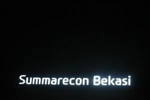 bekasi, indonésia em julho de 2022. o logotipo summarecon bekasi brilhando intensamente à noite contra o céu noturno escuro. foto