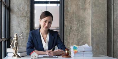 mulher de negócios ou advogados trabalhando na mesa de madeira no escritório. direito, serviços jurídicos, consultoria, leilão de juiz e conceito imobiliário. foto