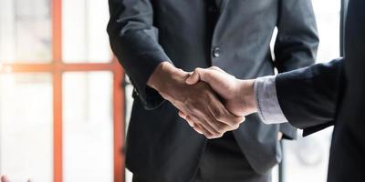 close-up de empresários apertando as mãos, terminando reunião, etiqueta empresarial, parabéns, conceito de fusão e aquisição foto