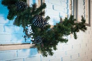 decoração de casa de inverno. árvore de natal no interior do sotão contra a parede de tijolos. foto
