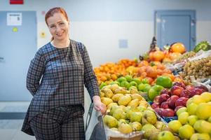 garota caucasiana comprando produtos alimentares de legumes frescos no mercado foto