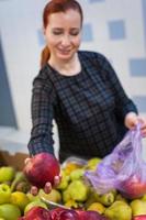 garota caucasiana comprando produtos alimentares de legumes frescos no mercado foto