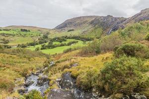 paisagem típica irlandesa com prados verdes e montanhas ásperas durante o dia foto