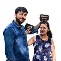 casal indiano posando para fotos de bebê maternidade com fundo branco liso. o casal está posando em um gramado com grama verde e a mulher está exibindo sua barriguinha de bebê no jardim lodhi em nova delhi, índia