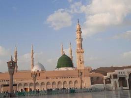 bela vista diurna de masjid al nabawi, cúpula verde de medina, minaretes e pátio da mesquita. foto