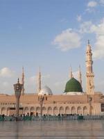 bela vista diurna de masjid al nabawi, cúpula verde de medina, minaretes e pátio da mesquita. foto