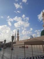 bela vista diurna de masjid al nabawi, cúpula verde de medina, minaretes e pátio da mesquita. foto