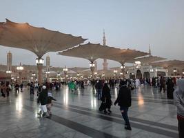 medina, arábia saudita, dezembro de 2022 - bela vista noturna em masjid al-nabawi, visitantes são vistos nas luzes da mesquita nas instalações da mesquita. foto