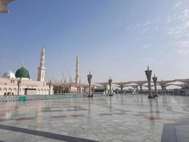 bela vista diurna de masjid al nabawi, cúpula verde de medina, minaretes e pátio da mesquita. foto