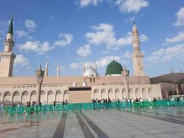 bela vista diurna de masjid al nabawi, cúpula verde de medina, minaretes e pátio da mesquita. foto