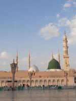 bela vista diurna de masjid al nabawi, cúpula verde de medina, minaretes e pátio da mesquita. foto