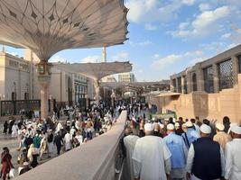 medina, arábia saudita, dezembro de 2022 - um grande número de peregrinos se reúne no pátio do lado de fora de masjid al nabawi. foto